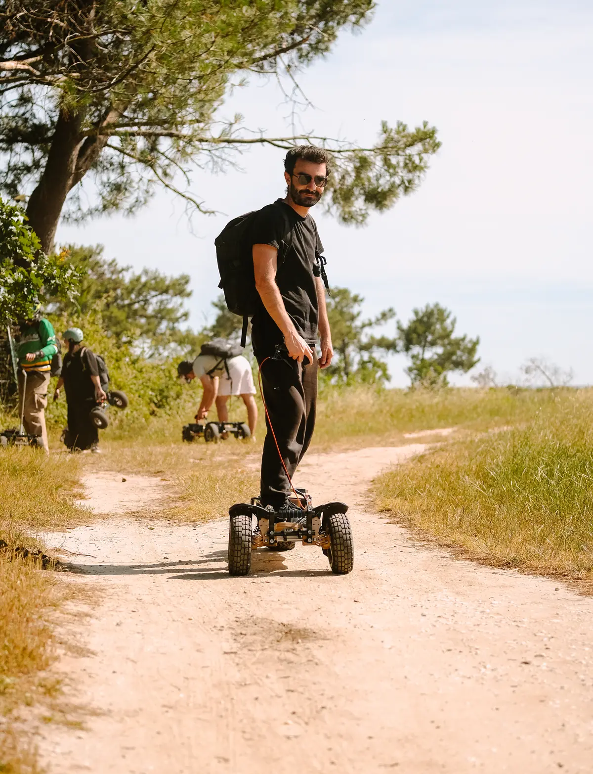 Adrien Ladan standing on a Stern' on a dirt track, wearing the backpack battery