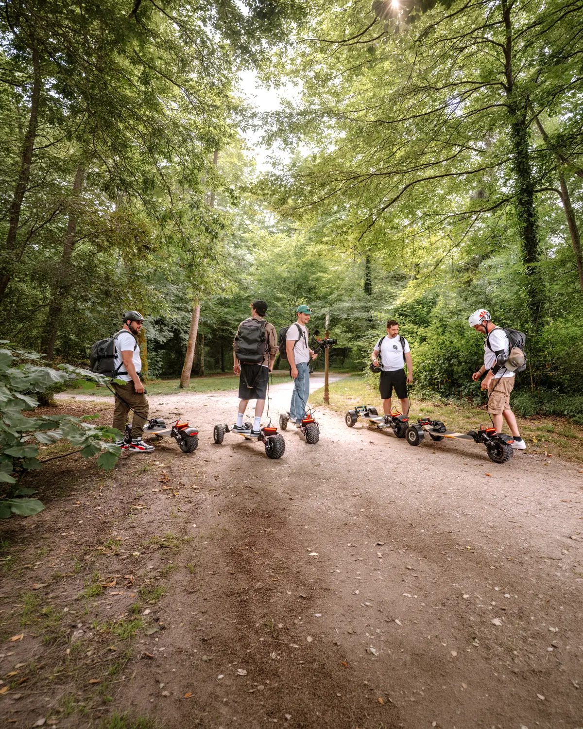 Group of five riders and their Stern' boards at a crossroads of forest tracks