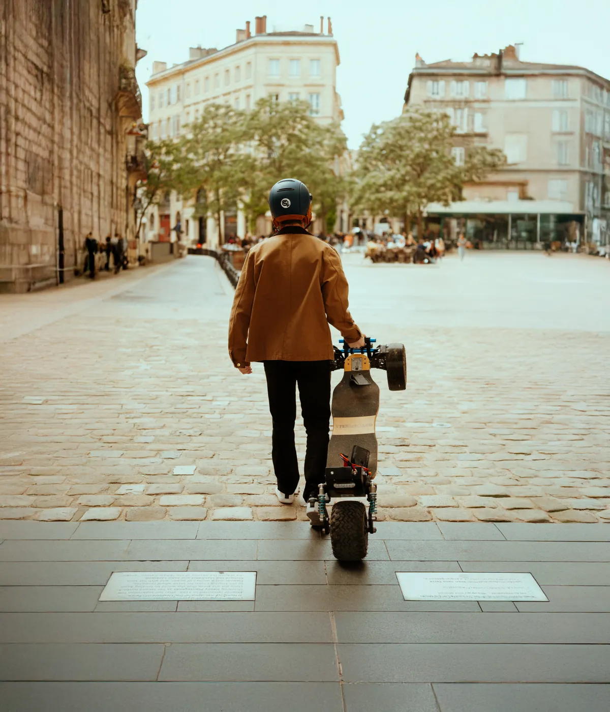 Rider carrying their Stern' by hand in a town street