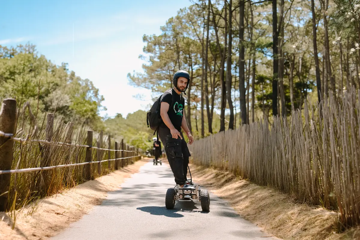 Helmeted rider on a Stern' on a dune access path lined with chestnut fencing