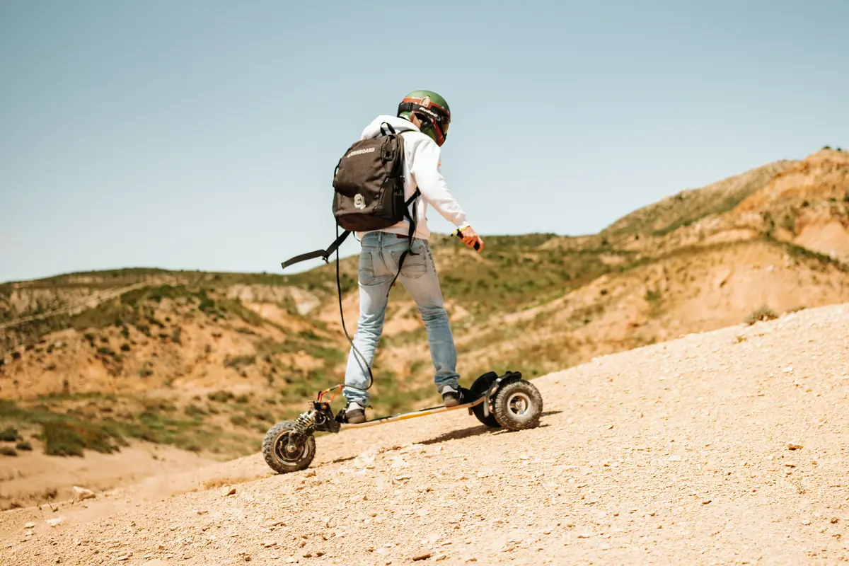Rider seen from behind riding down a sandy slope on their Stern'