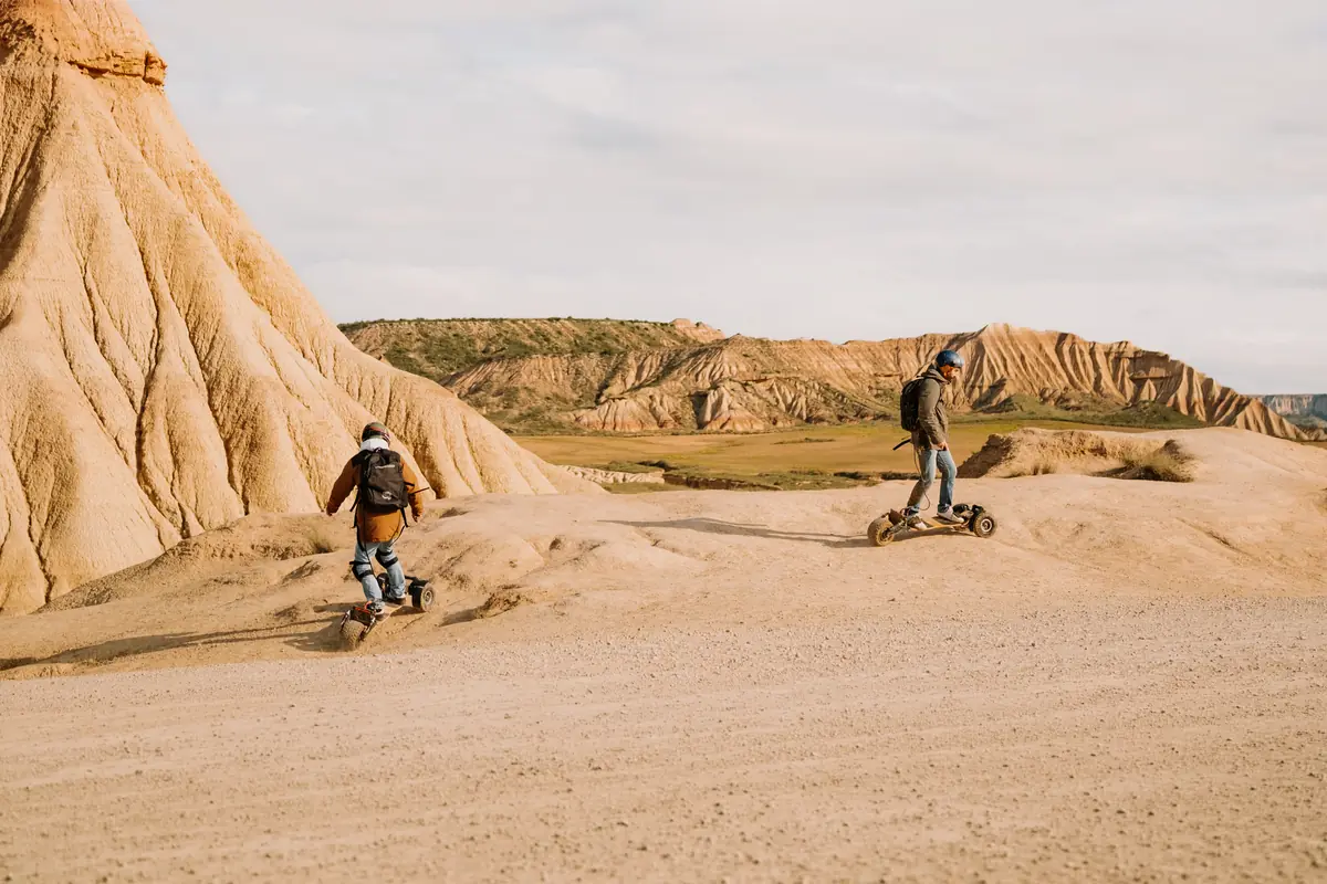 Two riders on Stern' boards at the foot of the sandy cliffs of the Bardenas desert