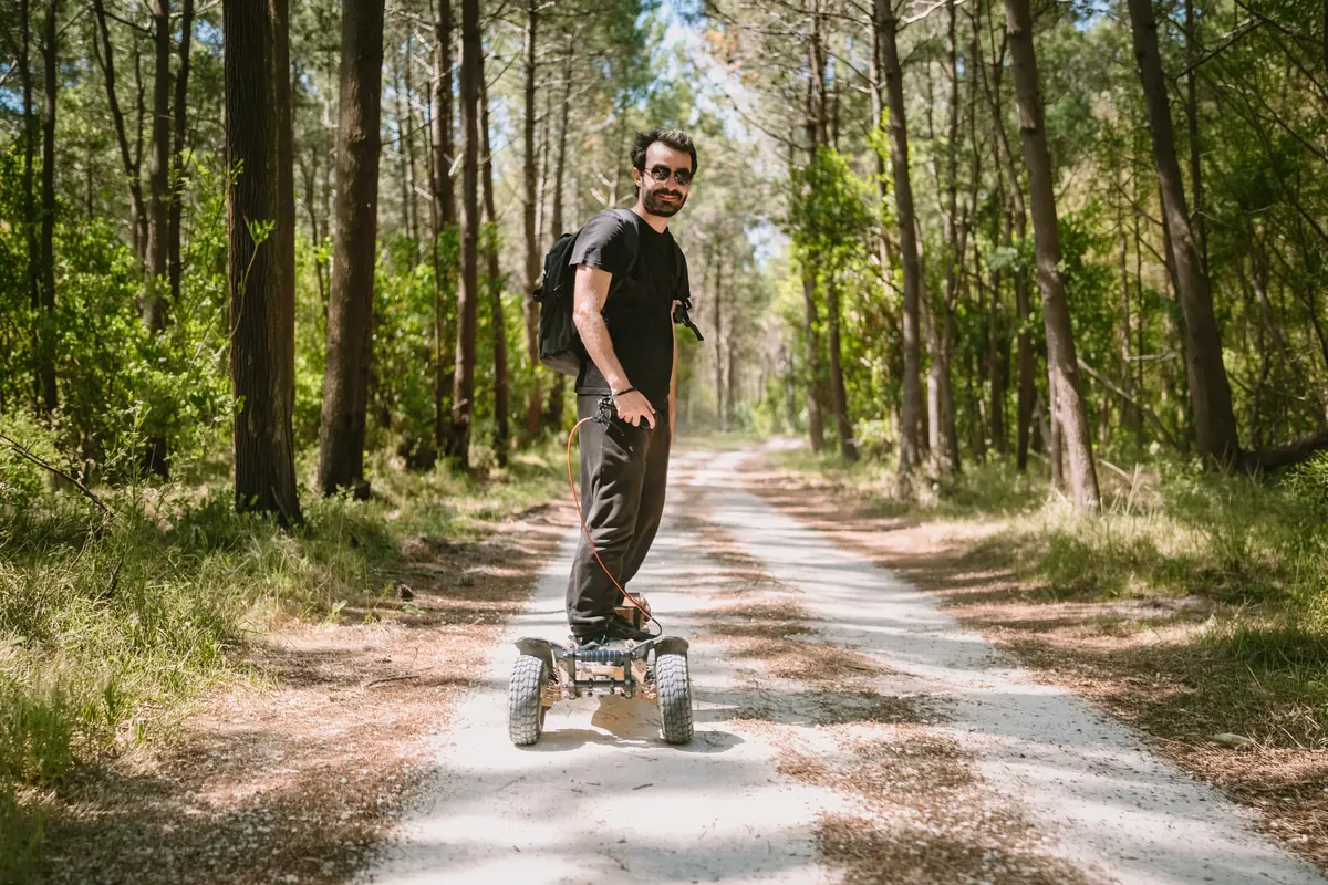 Rider souriant sur un Stern' sur une allée de sable blanc en forêt de pins