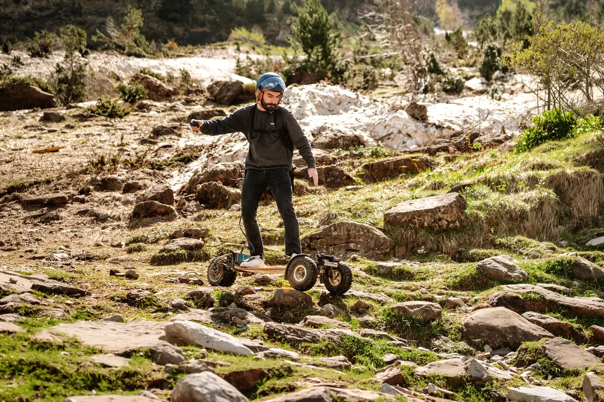 Helmeted rider riding down rocky mountain terrain on a Stern'